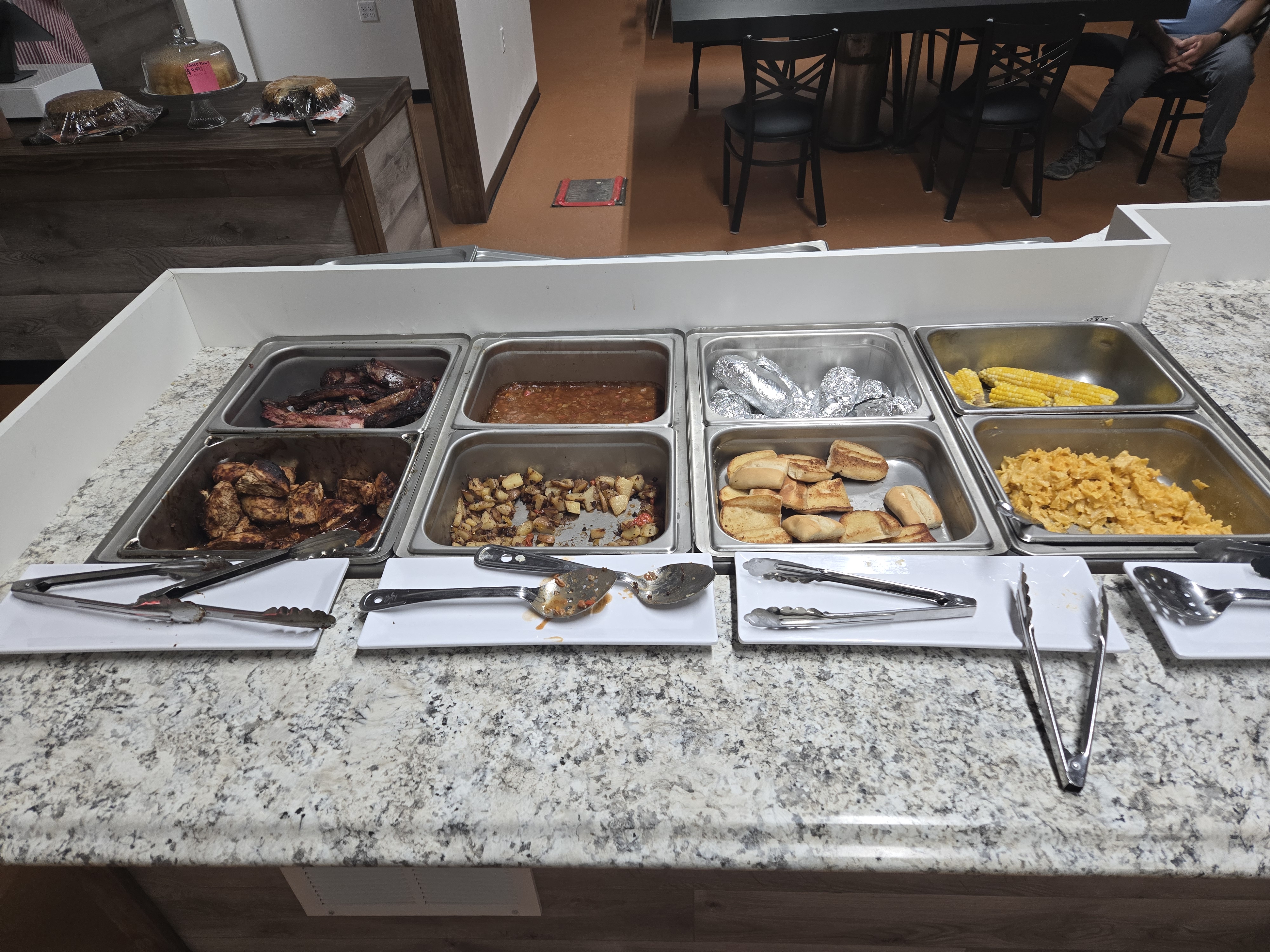 Buffet line at Big Tony's Supper House with ribs, chicken, beans, baked potatoes, corn, potatoes, rolls, and mac and cheese